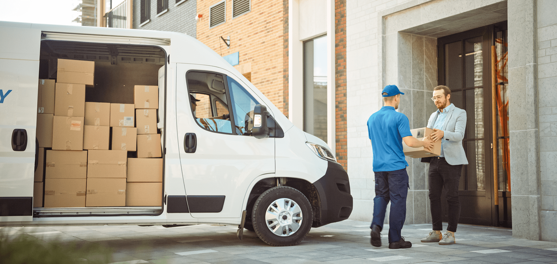 Delivery person handing package to a man.