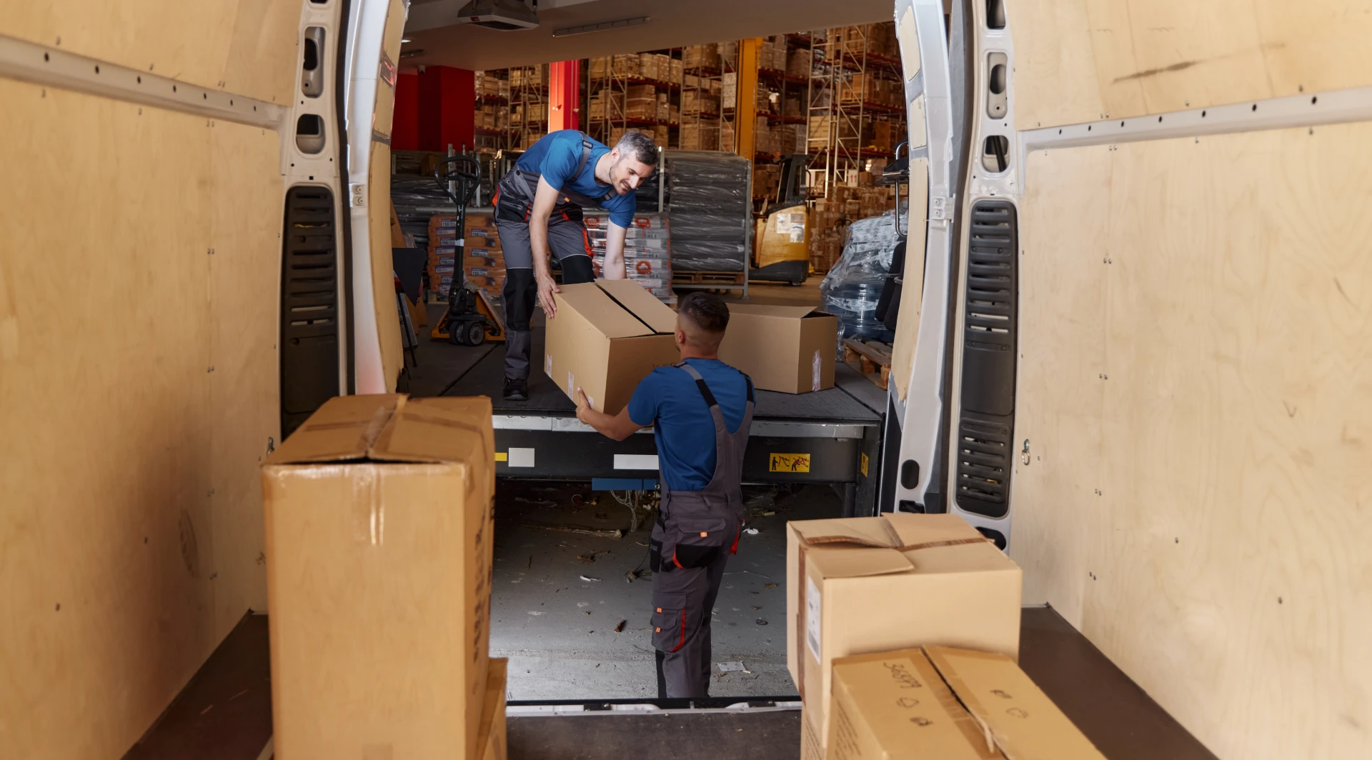 Workers loading boxes into delivery van.