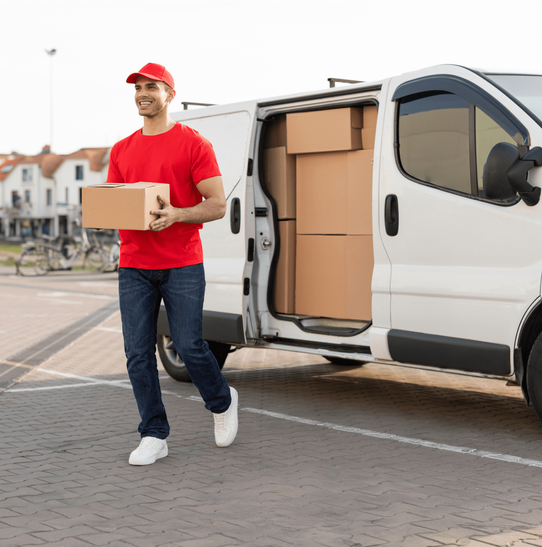 Delivery person carrying box near van.
